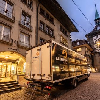 Ein Baumann Käse Lastwagen steht vor der Zytglogge in Bern in der Morgendämmerung